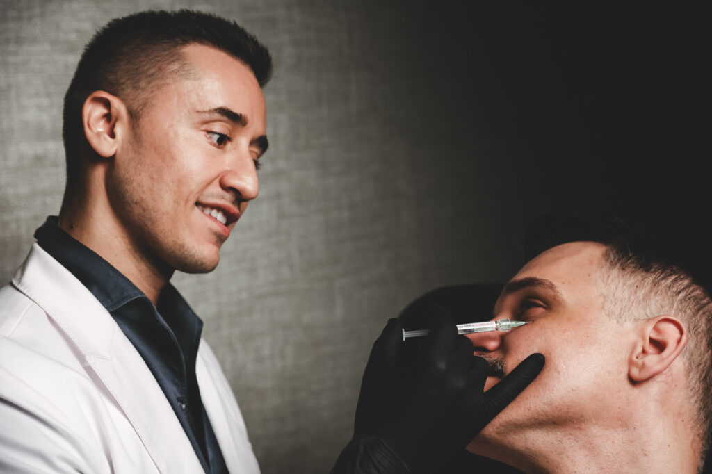 Dr. Akis smiles as he performs facial balancing in New York City