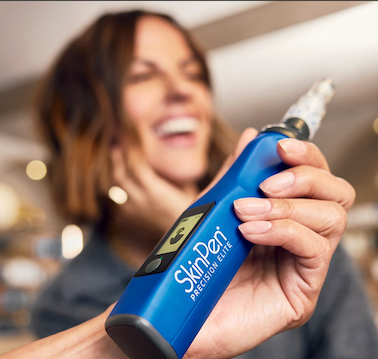 A patient smiles as a provider prepares a microneedling skin rejuvenation treatment in New York City
