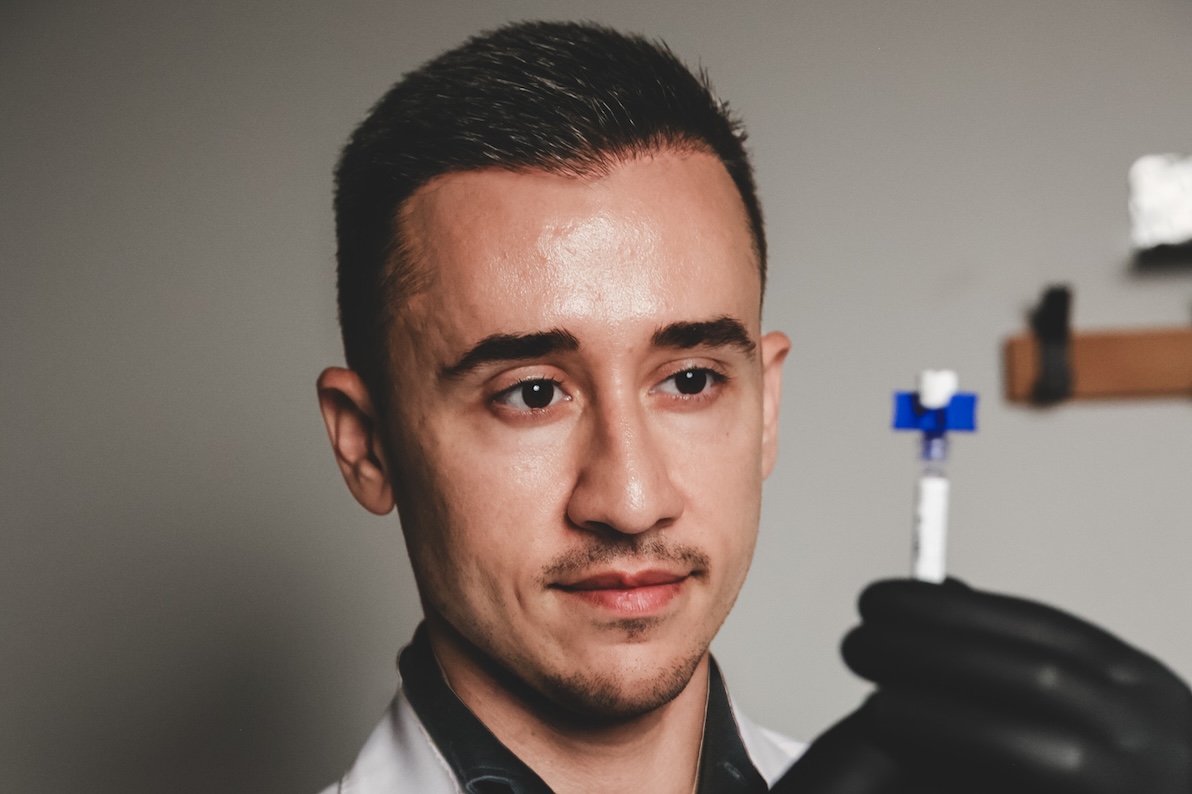 Dr. Akis at Aion Aesthetics holds a vial of PDGF-BB for under-eye bags treatment in New York City.